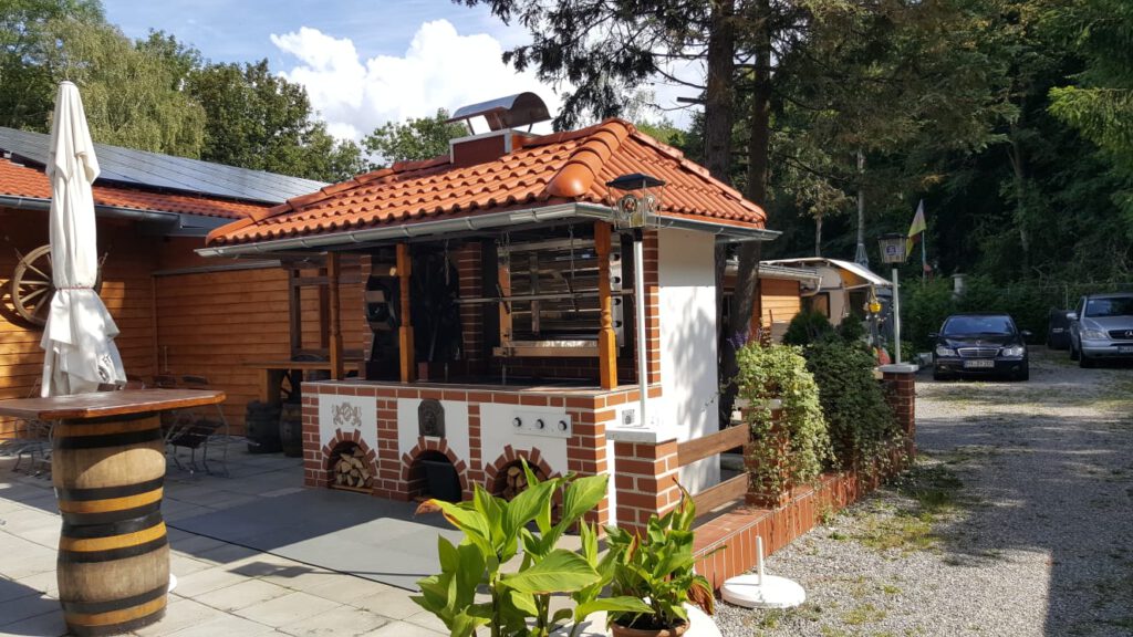 Terrasse mit großen Grillplatz mit professionellem Drehgrill